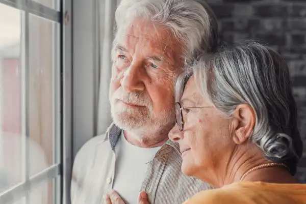 Couple looking distressed while discussing a recent mesothelioma diagnosis in a quiet home setting. Lung Cancer